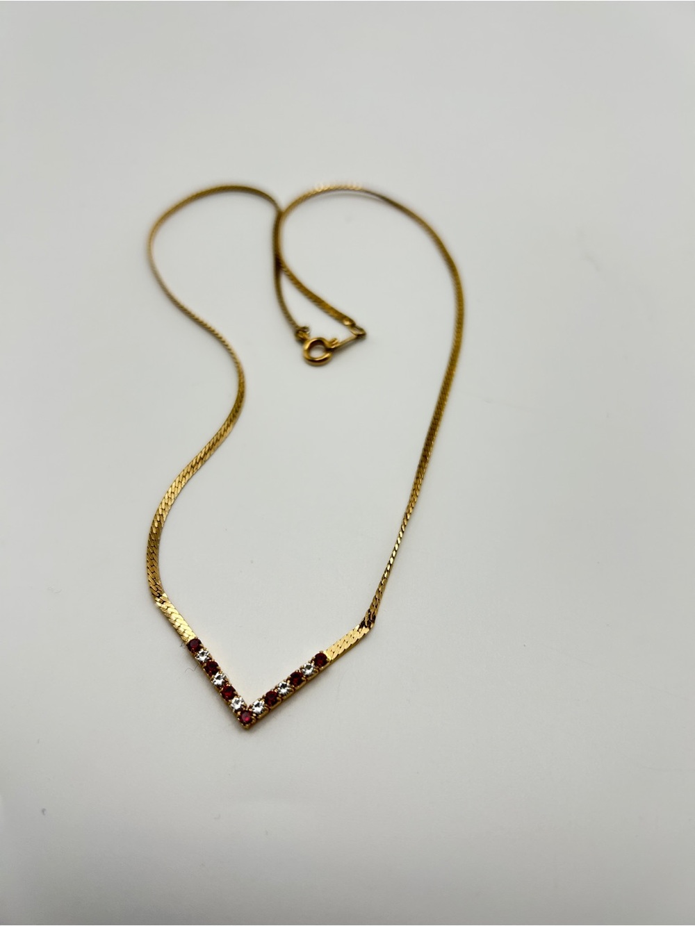 Vintage signed Avon gold-tone herringbone necklace featuring a striking V-shaped